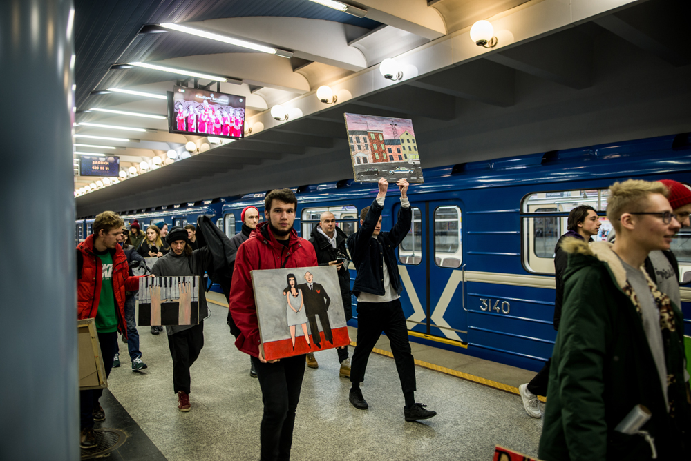 Белорусский художник сделал выставку в вагоне метро, одну из картин держит Бакей