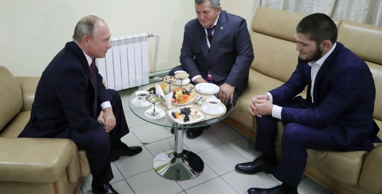 Путин со спортсменом и его отцом. Фото​: Reuters