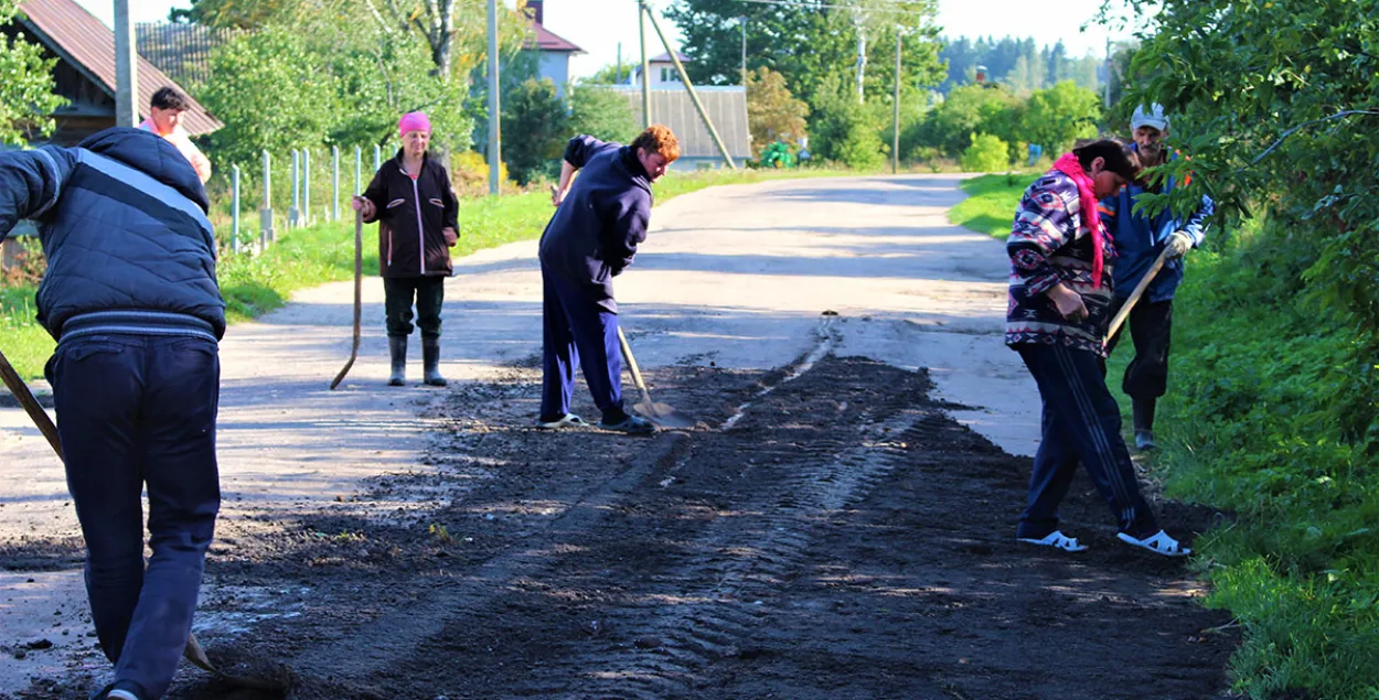 Жыхары вёскі самі робяць ямачны рамонт. Дарожнікі бясплатна забяспечылі іх матэрыяламі і тэхнікай.