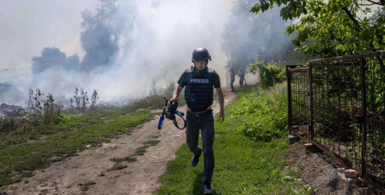 Дым после бомбардировки в Бахмуте за спиной журналиста / Bulent Kilic,&nbsp;AFP
