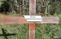 Повреждённая табличка с надписью &rdquo;Место сталинских расстрелов " / racyja.com​