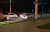 A protester running away by a taxi from the security forces / shot from the video