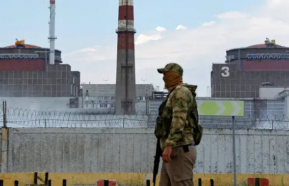 Российский военный на фоне второго и третьего энергоблоков ЗАЭС / Reuters
