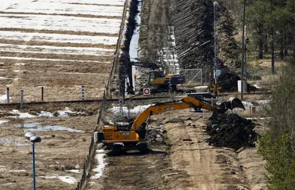 Экскаватары капаюць пясок каля памежнага плота з Расіяй / Reuters
