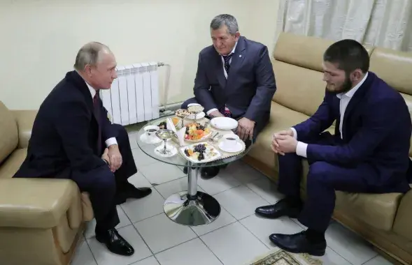Путин со спортсменом и его отцом. Фото​: Reuters