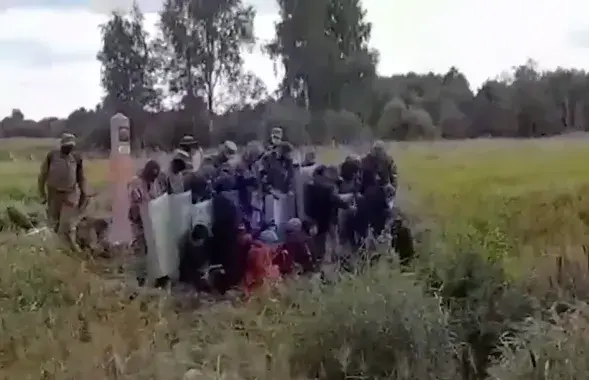 Людзі ў форме і са шчытамі пхаюць мігрантаў у бок Літвы / скрыншот відэа
