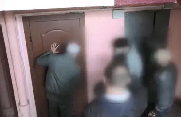Люди в штатском у квартиры минчанина Андрея Зельцера / скриншот видео
